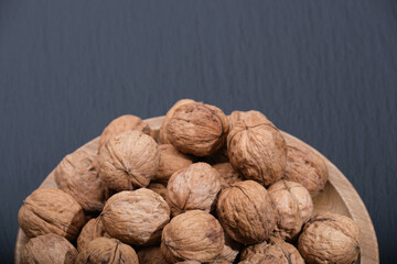 Group of walnuts on a black background. Walnut on black top view. Nuts on a wooden plate.