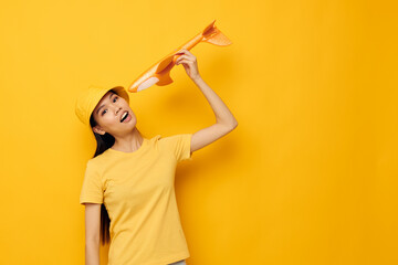 pretty brunette in a hat with an airplane in his hands model toy isolated background unaltered