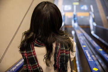 エスカレーターを降りる女性　escalator
