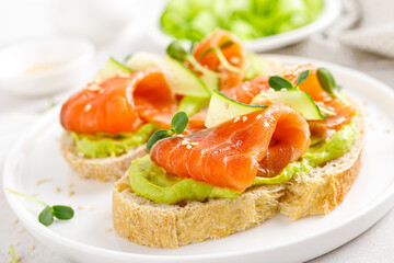Fototapeta na wymiar Open sandwiches with salted salmon, guacamole avocado and microgreens. Seafood. Healthy food.