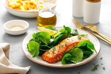 Grillet salmon and fresh spinach salad dressed with lemon