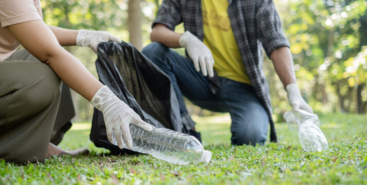 garbage collection, volunteer team pick up plastic bottles, put garbage in black garbage bags to clean up at parks, avoid pollution, be friendly to the environment and ecosystem