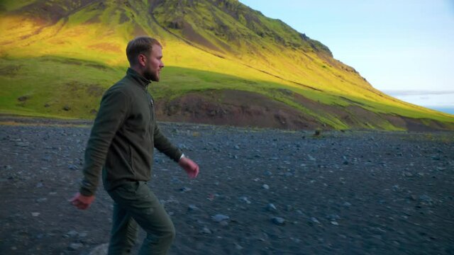 Bearded Tourist Man Walking In Scenic Natural Landscape To Seljavallalaug, South Iceland On A Beautiful Sunny Day. - Medium Shot, Tracking