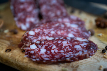 Smoked sausage and various spices on a wooden cutting board.