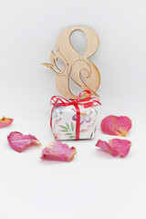 Greeting card with rose petals and a gift for March 8