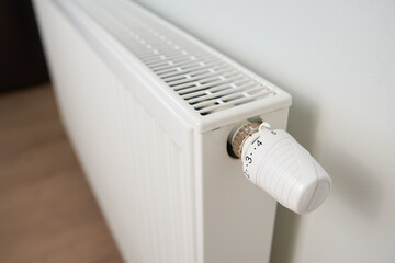 Adjusting temperature on heating radiator thermostat, Turning heat radiator knob to control heat in home