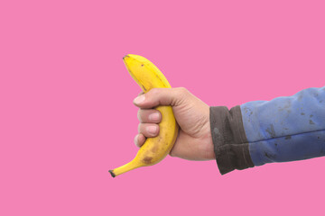 Banana as a symbol of male penis in hand on a yellow background hidden by censorship. Sexual masturbation and orgasm, impotence problem.