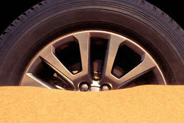 Close up of a car wheel stuck in the sand in the Namib desert.