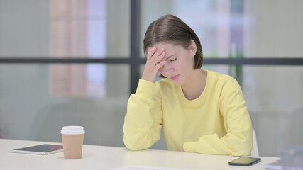 Upset Young Woman Feeling Worried While Sitting in Office