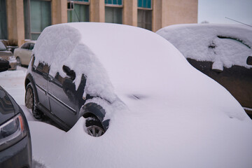 Parked cars completely covered with snow after snowfall