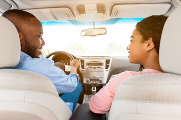 Happy black couple enjoying long drive on a car