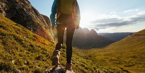 Solo woman backpacker hiking on alpine mountain peak