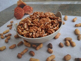 Walnut kernels in a bowl with jaggery and peanuts in background. Protein and fats rich foods. Walnut is a temperate fruit grown in hilly areas. 