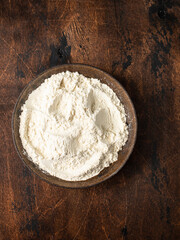 Bowl with wheat flour on a wooden background.  Egg.  Ingredients for the dough.  Rustic style.