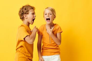 Portrait of cute children cuddling fashion childhood entertainment yellow background unaltered