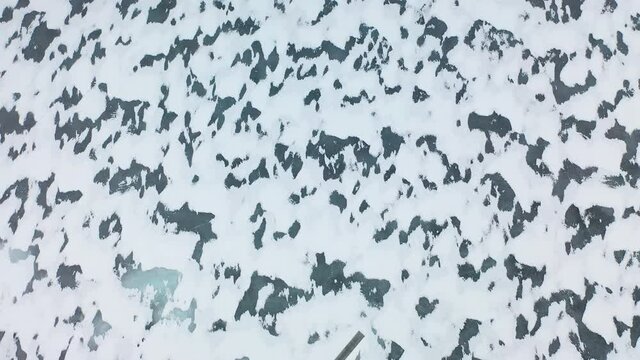 Aerial view of frozen ocean sea covered in snow. Beautiful shapes and patterns