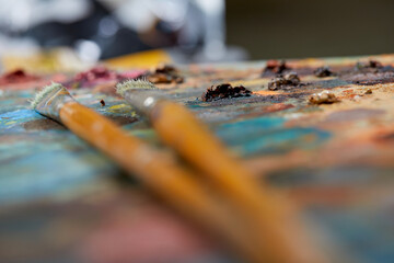 Tubes of oil paint, palette and artist paintbrushes closeup