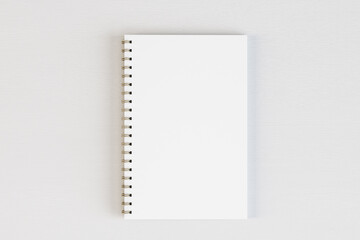Top view of empty white spiral notepad on light desktop background. Mock up, 3D Rendering.
