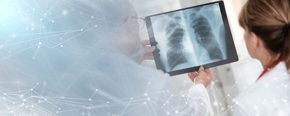 Two doctors examining x-ray report; panoramic banner