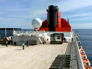 Passengers enjoying open outdoor promenade sun decks of legendary ocean cruiseship cruise ship...