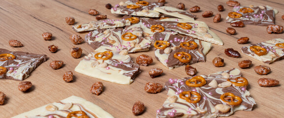 Weiße und braune Schokolade vorbereitet für eine Bruchschokolade dekoriert mit Brezel, Zucker...