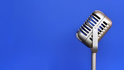 Vintage and retro concept. Vintage classic microphone on blue background with copy space for text