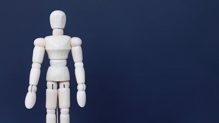 Close up image of wooden doll on black background with copy space.