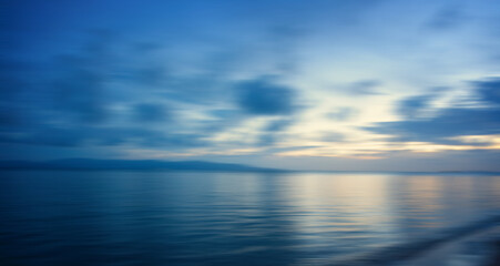 Blurred blue sea background at sunset, abstract natural background