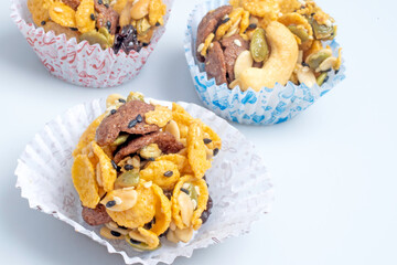 Cereal Cookies in a paper cup on a white background, Pumpkin, oat cookies with cranberries, cashew nut, sesame. soft focus.