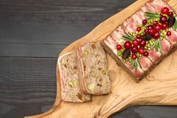 Traditional French terrine covered with bacon on dark wooden background