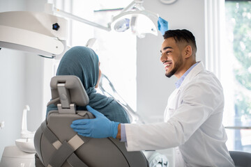 Arab Dentist Making Check Up To Muslim Female Patient In Stomatological Clinic