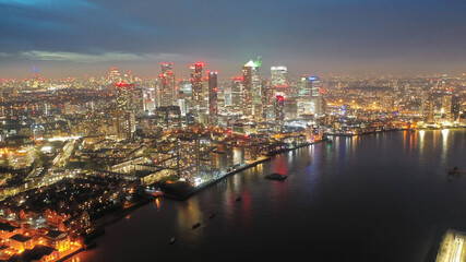 Fototapeta na wymiar Aerial drone night shot of iconic illuminated with Christmas lights skyscraper banking and business complex of Canary Wharf, Docklands, London, United Kingdom