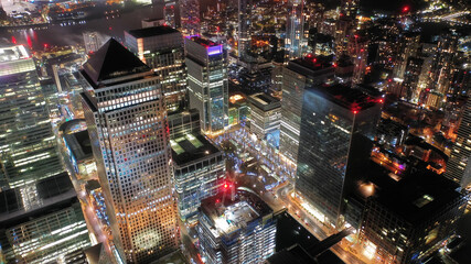 Aerial drone night shot of iconic illuminated with Christmas lights skyscraper banking and business complex of Canary Wharf, Docklands, London, United Kingdom © aerial-drone