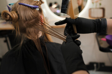 .Close-up of female hands holding the hair rows in professional hairstyles salon. The hairdresser...