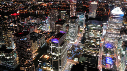 Aerial drone night shot of iconic illuminated with Christmas lights skyscraper banking and business complex of Canary Wharf, Docklands, London, United Kingdom