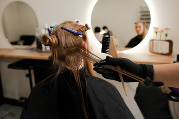 .Close-up of female hands holding the hair rows in professional hairstyles salon. The hairdresser...