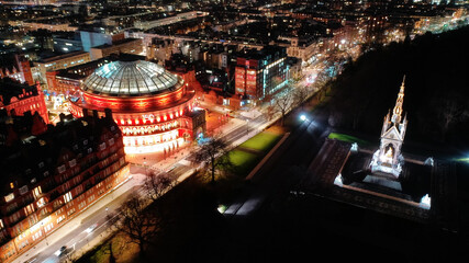 Aerial drone night shot of illuminated Royal Albert hall and Albert Memorial in Kensington area,...