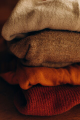 Fototapeta na wymiar folded wool sweaters. warm multi-colored wool sweaters one on one. autumn mood for warm clothes.