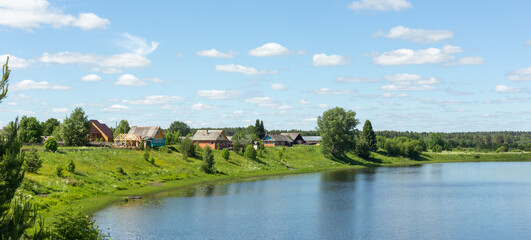 Fototapeta na wymiar Typical Russian landscape. Russian village on the shore of the lake. Panoramic photo