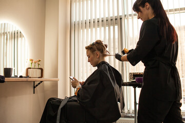 .Close-up of female hands holding the hair rows in professional hairstyles salon. The hairdresser...