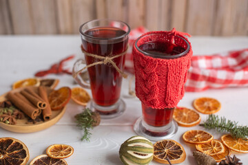 Mulled hot wine with spices with dry fruits in cups on wooden table