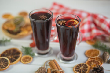 Mulled hot wine with spices with dry fruits in cups on wooden table