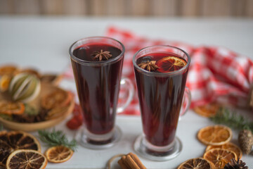 Mulled hot wine with spices with dry fruits in cups on wooden table
