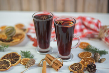 Mulled hot wine with spices with dry fruits in cups on wooden table