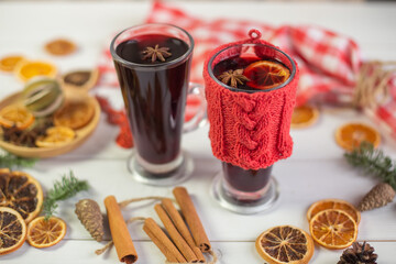 Mulled hot wine with spices with dry fruits in cups on wooden table