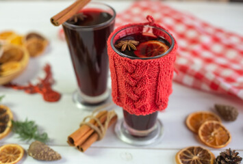 Mulled hot wine with spices with dry fruits in cups on wooden table