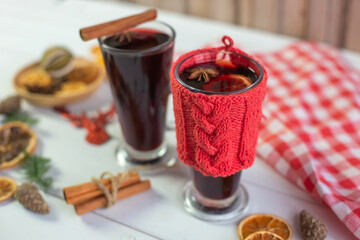 Mulled hot wine with spices with dry fruits in cups on wooden table