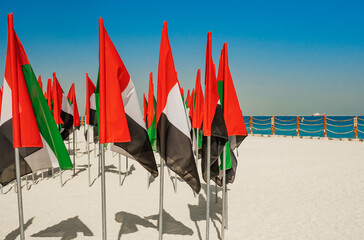 Flags United Arab Emirates at Kite Beach in Dubai. Celebration of National Day - Day of the United Arab Emirates Many flags of the UAE at sand.