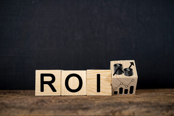 Wooden block with growth icon and ROI text isolated on black background.