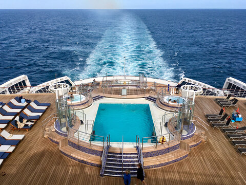 Fototapeta Passengers enjoying open outdoor promenade sun decks of legendary ocean cruiseship cruise ship liner Queen Mary 2 during Transatlantic crossing on sunny day with blue sky